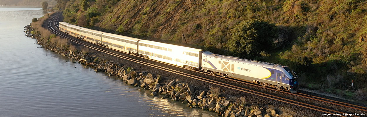 Banner image of an Amtrak train with a Caltrans logo. Amtrak California is a service operated by Amtrak that runs on tracks managed by Caltrans. Photo courtesy of CapitolCorridor.org. 