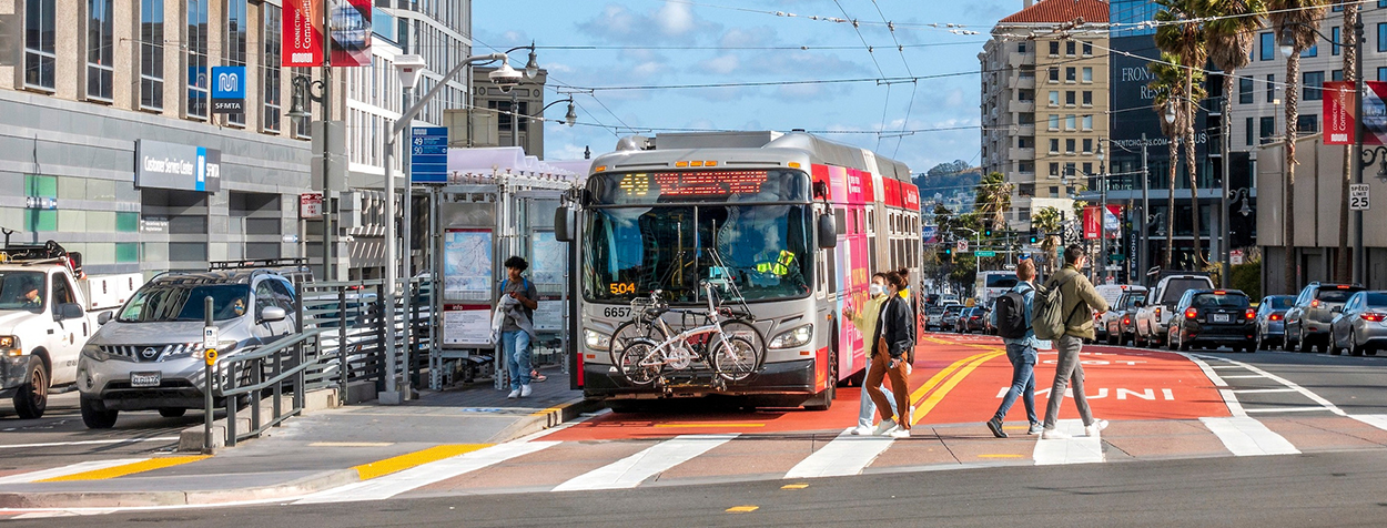 Banner image of people walking in crosswalk in front the 49 MUNI bus in San Francisco.
