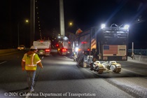 Heavy equipment and trucks are used to remove the roadway surface on the Alfred Zampa Memorial (Carquinez) Bridge on the night of August 21, 2026. The northern bridge tower is visible in the background.