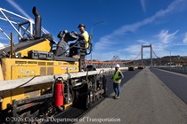 Heavy equipment is used to apply new roadway material as part of the bridge deck rehabilitation project on the Al Zampa Bridge on August 22, 2026.