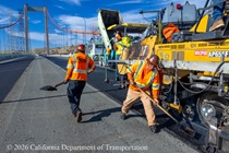 Heavy equipment and shovels are used to apply new roadway material as part of the bridge deck rehabilitation project on the Al Zampa Bridge on August 22, 2026.