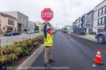Caltrans worker directing traffic to stop as Caltrans continues to resurface of SR-1 to replace the existing asphalt pavement on Northbound 19th Avenue from Sloat Boulevard to Lincoln Way as work continues on the 19th Avenue Paving and Rehabilitation project.