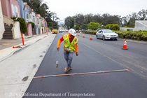 Caltrans worker marking the newly paved asphalt on Northbound 19th Avenue from Sloat Boulevard to Lincoln Way as work continues on the 19th Avenue Paving and Rehabilitation project.
