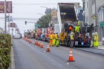 A Caltrans crew uses heavy equipment to apply new asphalt on southbound 19th Avenue (State Route 1) on May 10, 2026. The left lane remains open to vehicle traffic.