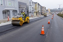 A Caltrans crew uses heavy equipment to smooth new asphalt on southbound 19th Avenue (State Route 1) on May 10, 2026. The left-hand lane remains open to vehicle traffic.