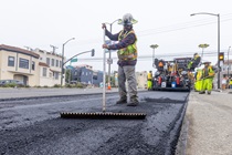 A Caltrans crewmember uses a long-handled tool while applying new asphalt on southbound 19th Avenue (State Route 1) as part of the 19th Avenue Paving and Rehabilitation Project on May 10, 2026. 
