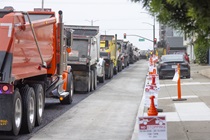 Trucks loaded with asphalt lined up on southbound 19th Avenue (State Route 1) as part of the 19th Avenue Paving and Rehabilitation Project on May 10, 2026. No parking signs line the sidewalk.