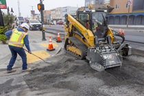 Caltrans crew using heavy equipment and shovels to prepare and resurface the existing asphalt pavement on Southbound 19th Avenue as work continues on the second of three weekend closures for 19th Avenue (State Route 1) Rehabilitation Project in City of San Francisco.