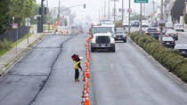 A Caltrans crewmember adjusts orange traffic cones on southbound 19th Avenue (State Route 1) near Wawona Street on May 10, 2026. Vehicle traffic flows in the left-hand lane.