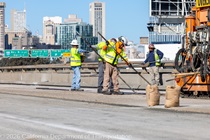 Caltrans crews finishing up the newly completed polyester overlay on the WB I-80 Bayshore Freeway as cars drive by on the open lanes on October 24, 2026. The purpose of this closure is to perform the polyester overlay of the Bayshore viaduct between 4th street and the I-80/US-101 interchange.