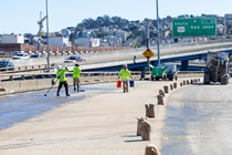 Caltrans crews finishing up the newly completed polyester overlay on the WB I-80 Bayshore Freeway as cars drive by on the open lanes on October 24, 2026. The purpose of this closure is to perform the polyester overlay of the Bayshore viaduct between 4th street and the I-80/US-101 interchange.