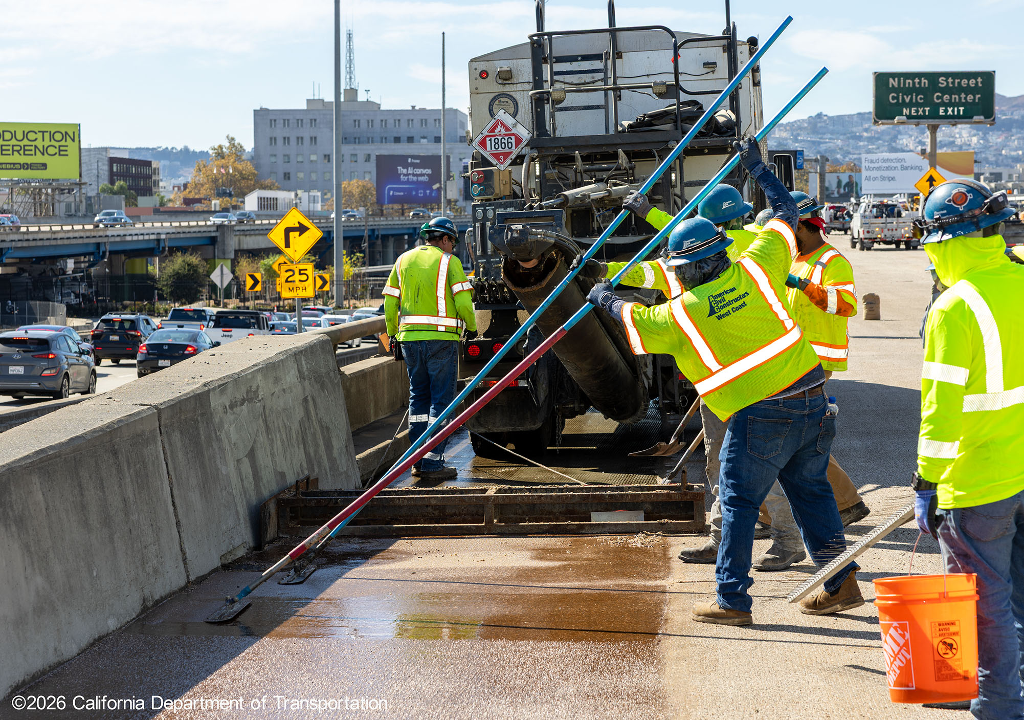 Caltrans crew with heavy equipment applying the polyester overlay on WB I-80 Bayshore Freeway as cars drive by in the open lanes on October 25, 2026. The purpose of this closure is to perform the polyester overlay of the Bayshore viaduct between 4th street and the I-80/US-101 interchange.