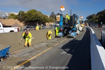 Caltrans crew performs finishing work on the fresh concrete of the new median barrier on US 101 in San Francisco.