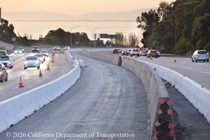 Segment of new concrete median on US 101 in San Francisco. Temporary barriers separate traffic from the new median construction.