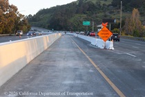 An orange sign alerts drivers to be aware of trucks entering and leaving the work zone on US 101 in San Francisco.