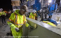 Caltrans crew member performs finishing work on the fresh concrete for the new median barrier as part of the US 101 Hospital Curve Rehabilitation Project on March 27, 2026.