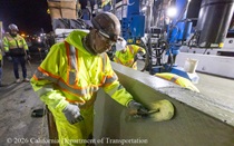 Caltrans crew member performs finishing work on the fresh concrete for the new median barrier as part of the US 101 Hospital Curve Rehabilitation Project on March 27, 2026.
