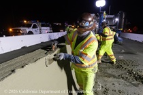 Caltrans crew member performs finishing work on the fresh concrete for the new median barrier as part of the US 101 Hospital Curve Rehabilitation Project on March 27, 2026.