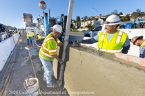 Caltrans crew member performs finishing work on the fresh concrete for the new median barrier as part of the US 101 Hospital Curve Rehabilitation Project on March 28, 2026.