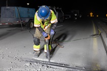 A crew member works on the removal of the old roadway material on southbound US-101 during the night of October 16, 2026.