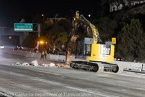 Heavy equipment is used to remove the old roadway material on southbound US-101 neat the Vermont Street off-ramp during the night of October 16, 2026.