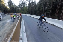 A bicyclist travels past the slide repair work on State Route 84 in San Mateo County on October 5, 2023.