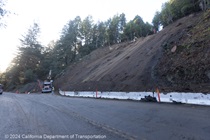 Caltrans removing fallen trees, debris,  cleaning drainage system, and regrading slope on State Route 9. Mudslide at the entrance to Savannah Chan Vineyards, dirt excavation, earthwork, hillside mostly graded smooth.