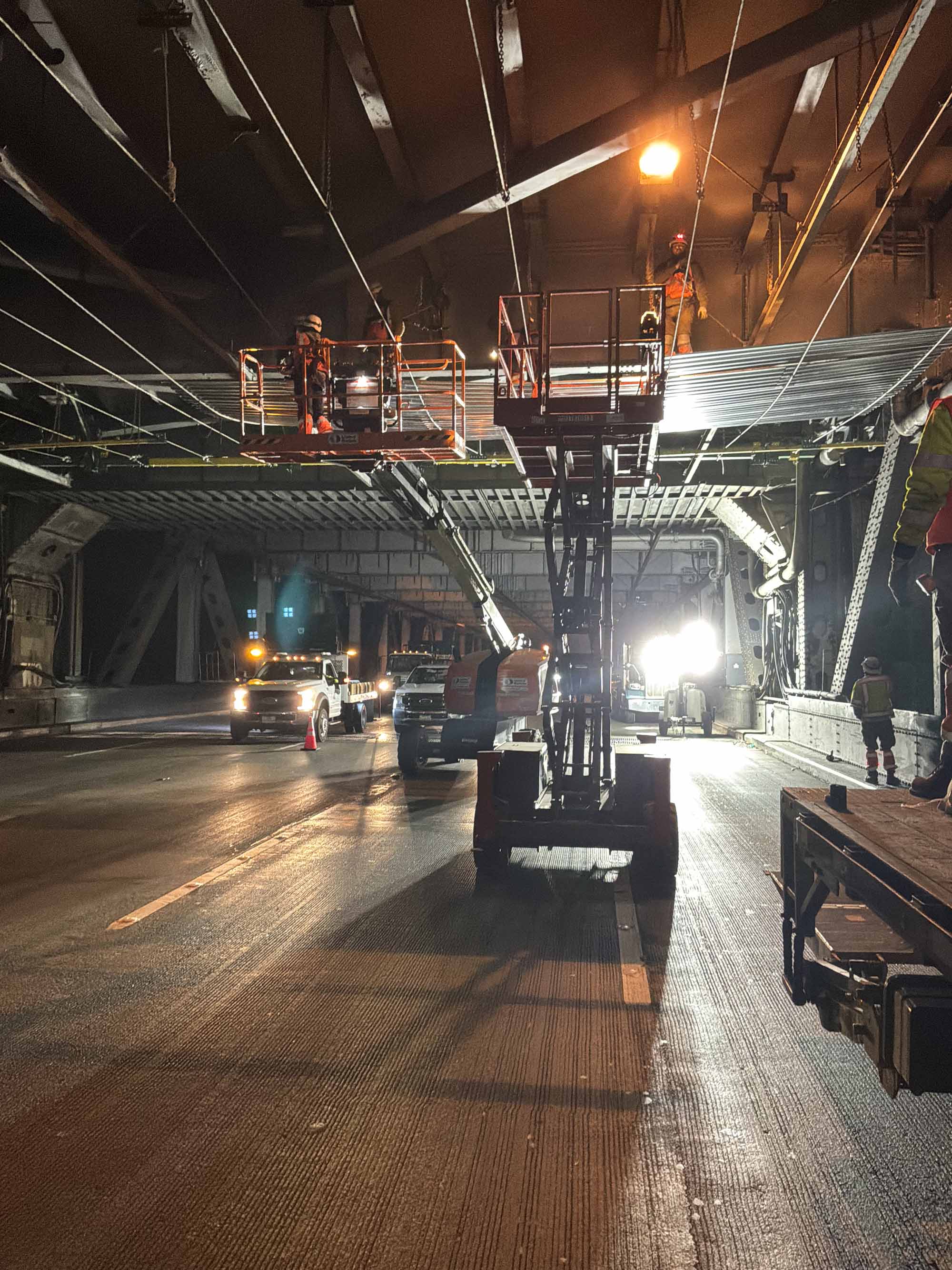 Crew installing corrugated sheets which will serve as a protective foundation for crew to safely work and apply paint.