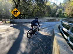 A bicyclist turn right onto the Saratoga Creek Bridge along State Route 9 in Santa Clara County.