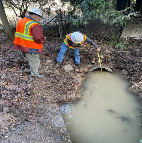 Two Caltrans employees inspect a damaged culvert near Calistoga, California.