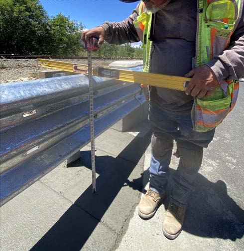 Caltrans worker leveling a new guardrail on State Route 29 between the Napa River (George F. Butler Memorial) Bridge and Trancas Street for the SR-29 Guardrail Project.
