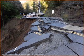 Photograph of the slide damaged roadway on State Route 84 where the roadway material has broken apart into large pieces and a portion of the roadway is missing, having slid down the hillside.