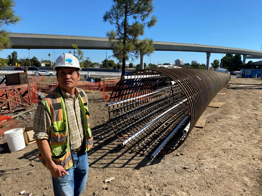 Construction Manager Peter Lam standing next to 140-foot rebar cage, in the work area.