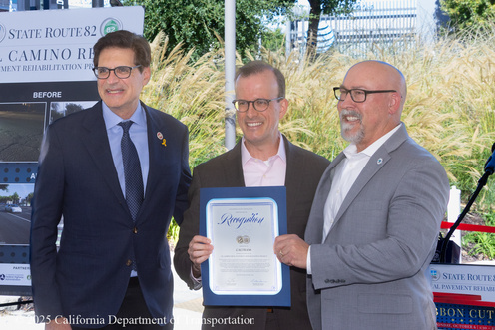 State Senator Josh Becker (left), Assemblymember Marc Burman (center), and Acting Caltrans Director for District 4 David Ambuehl (right) hold a declaration for the completion of the State Route 82 (SR-82) El Camino Real Paving Rehabilitation Project.