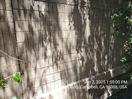 Photograph of a soundwall near Elwood Drive in Los Gatos after graffiti removal. The soundwall has been restored to its standard beige color.