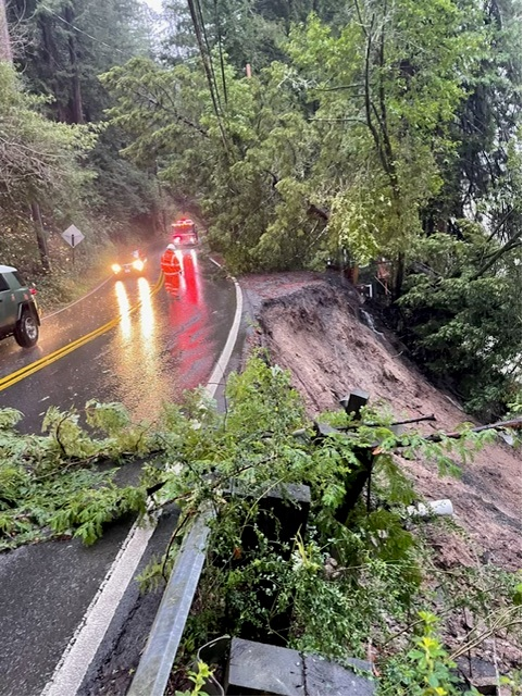 One lane remains open to traffic on State Route 116 near Monte Rio in Sonoma County while a Caltrans employee inspects a landslide along the eastbound shoulder of the roadway.