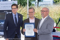 State Senator Josh Becker (left), Assemblymember Marc Burman (center), and Acting Caltrans Director for District 4 David Ambuehl (right) hold a declaration for the completion of the State Route 82 (SR-82) El Camino Real Paving Rehabilitation Project.