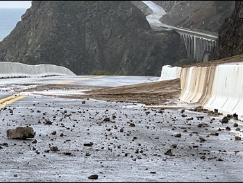 Photo showing rock and debris overtopped the concrete barriers on the northbound shoulder of Highway 1 at Regent's Slide