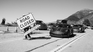 Black and white photo of "Road Closed" signs being moved and cars waiting to drive through fixed Regent's Slide area