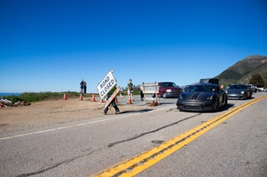 Photo showing first cars driving through the newly re-opened highway 1 in Big Sur