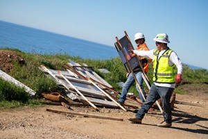 Staff moving road closure signs to the side, officially opening the highway 1