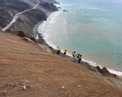 Photo of construction crew scaling side of the hill