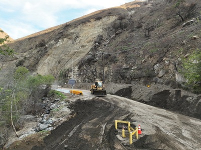 Photo showing machinery performing cleanup and repair progress along SR-27