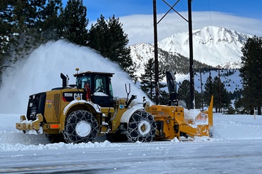 A snowblower blowing snow from the highway in Mono County.