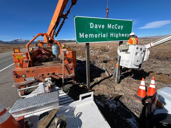 Caltrans maintenance workers install the Dave McCoy Memorial Sign on U.S. 395.