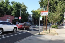Class 4 bicycle lane on a road separated with parked cars and signage in Sacramento, California
