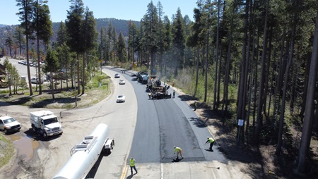 Workers paving the highway with hot mix asphalt