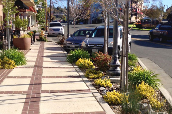 Photo of Main Street Improvement Examples: A main street improvement project on State Route 49/143 (High Street) in Auburn improved traffic flow, increased the visual appeal of the street, and included sustainable design features such as a storm water treatment planter area with street trees and landscaping.