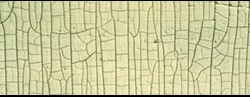 A uniform distribution of surface cracking in a symmetrical pattern resembling the skin of an alligator.