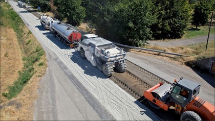 aerial view of a full depth reclamation train performing work on pavement during day construction